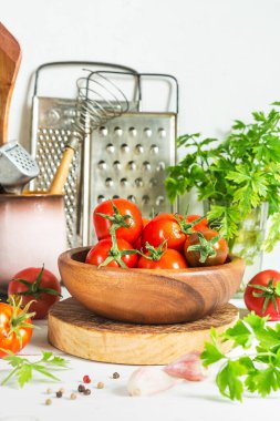 Bir kasede ve beyaz ahşap bir masada farklı türde domates sebzeleri, korunma hazırlığı. Kırsal bir hayat sürüyor.