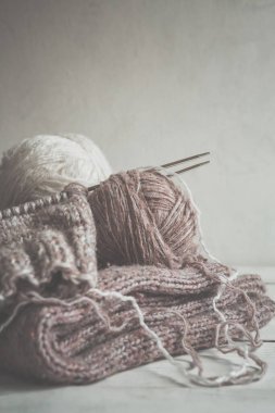 İskandinav stili monokromda kopya alanı olan el yapımı hobi için yün iplik ve örgü iğneleri.