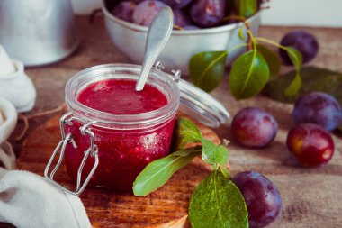 Cam kavanozdaki meyveli erik reçeli ve fotokopi alanı olan bir masada böğürtlen.