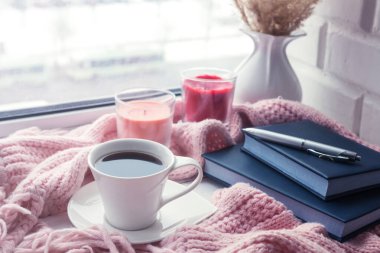 Masanın üzerinde beyaz fincanda bir fincan kahve. 