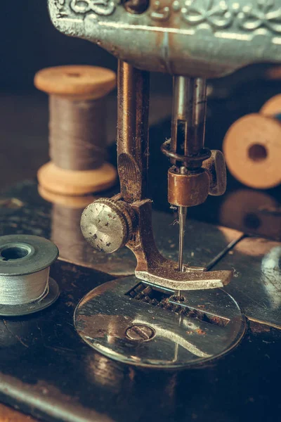 Eski dikiş makinesi retro, kaba bir planın detayları, iplik sargıları, klasik tarzda, bir terzi giysi tarihi seçici odaklanma konsepti.
