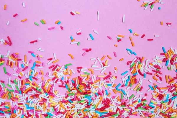 Veelkleurige Confetti Een Roze Achtergrond Bovenaanzicht — Stockfoto