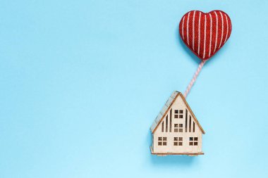 düz üst görünümü, kalp şeklinde bir balon üzerinde uçan kalp ile ahşap ev, aile kavramı, ev, hediye, pastel arka plan sevgililer günü