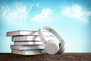 Beyaz kulaklık ve kitaplar, konsept kitaplar sesli kitaplar ve e-öğrenme, e-kitap