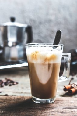 bir fincan kahve ve kahve çekirdekleri tarçın ile natürmort ahşap bir masa üzerinde oturma odasında sopa, Konfor ve İskandinav tarzı hugge iç kavramı