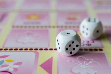 masa oyunları kavramı. Pembe arka planda zarlar, cipsler ve kartlar