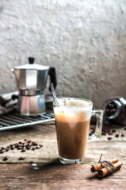 bir fincan kahve ve kahve çekirdekleri tarçın ile natürmort ahşap bir masa üzerinde oturma odasında sopa, Konfor ve İskandinav tarzı kucaklama iç kavramı