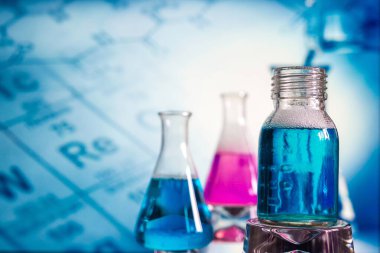 Laboratuvarın arka planına karşı reaksiyon sırasında renkli sıvı ile dolu bir kimyasal laboratuvarda cam, kimyasal deneyim, tıpta teknolojiler, ilaç