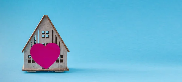 Wooden house with heart concept of family, love in home, comfort, gift, valentine's day on pastel background — Stock Photo, Image