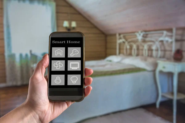 Smart home technology interface on smartphone app screen with augmented reality (AR) view of internet of things (IOT) connected objects in the apartment interior, person holding device