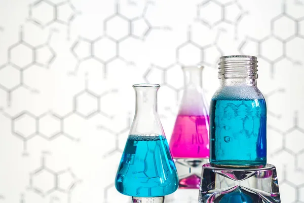 Glass in a chemical laboratory filled with colored liquid during a reaction against the background of the laboratory, chemical experience, technologies in medicine, pharmaceuticals