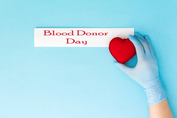 hand gives a red heart to a hand - blood donation,world blood donor day medical background