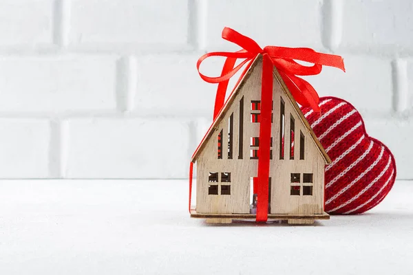 Holzhaus mit Herzkonzept der Familie, Liebe zu Hause, Komfort, Geschenk, Valentinstag auf pastellfarbenem Hintergrund — Stockfoto