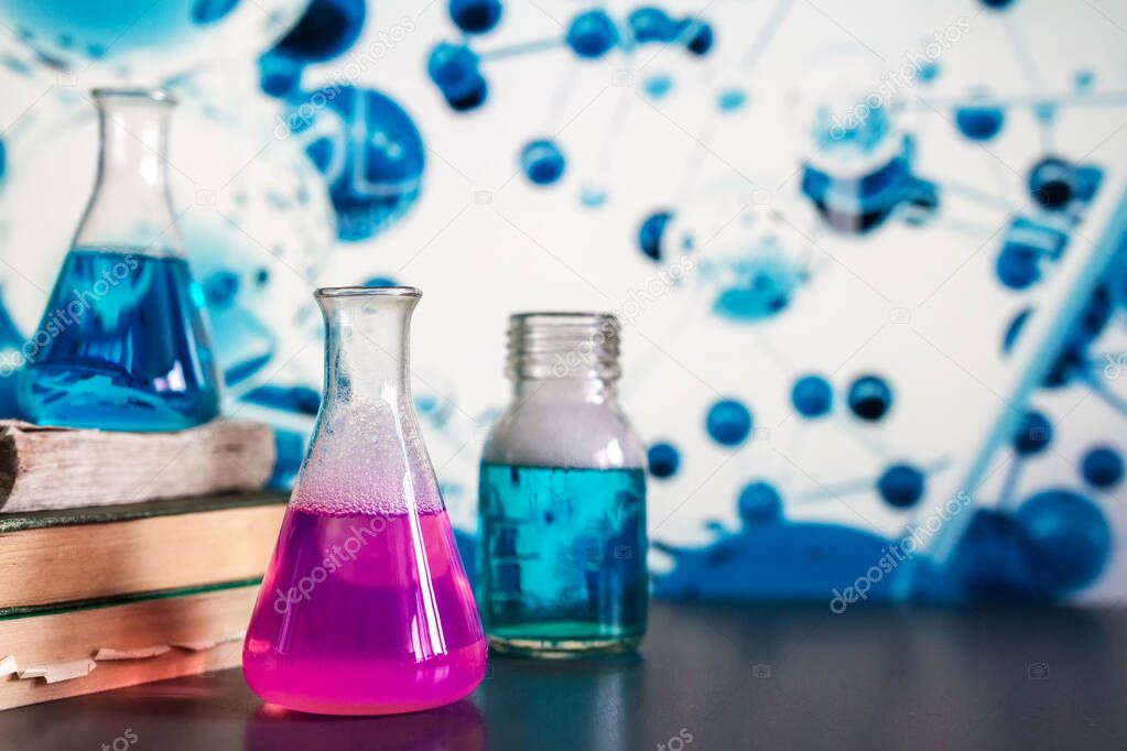 Glass in a chemical laboratory filled with colored liquid during a reaction against the background of the laboratory, chemical experience, technologies in medicine, pharmaceuticals