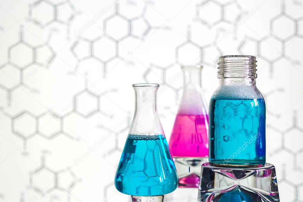 Glass in a chemical laboratory filled with colored liquid during a reaction against the background of the laboratory, chemical experience, technologies in medicine, pharmaceuticals