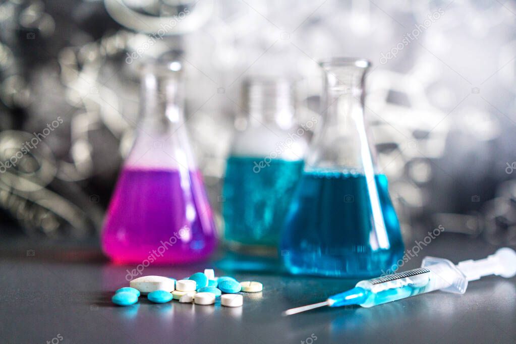 Glass in a chemical laboratory filled with colored liquid during a reaction against the background of the laboratory, chemical experience, technologies in medicine, pharmaceuticals