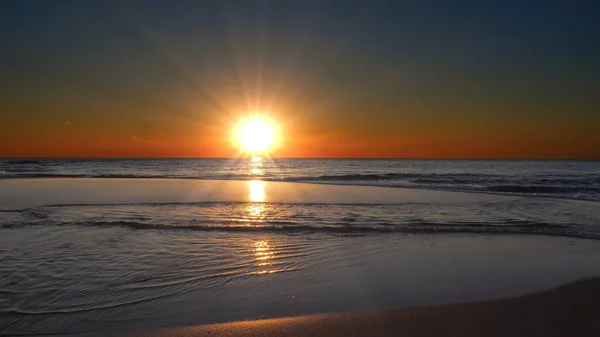 Солнце Скрывается Горизонтом Фоне Песчаного Пляжа — стоковое фото