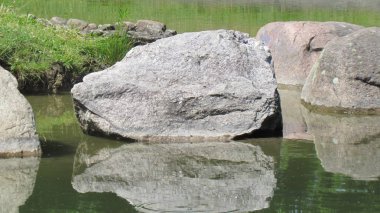 Büyük taşlar kıyıya yakın suda yatıyor
