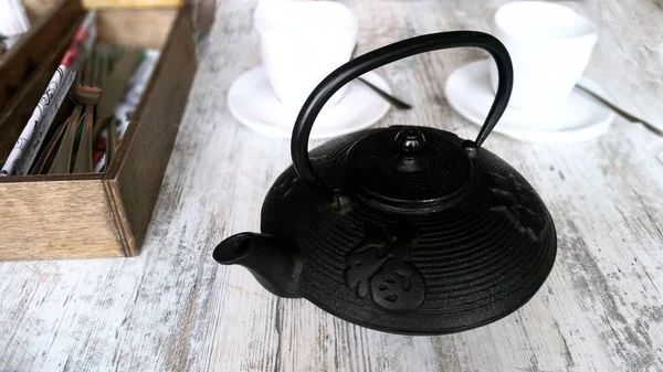 Tea cup and teapot on wood plank outside the door — Stock Photo, Image
