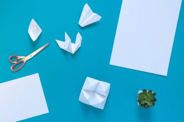 temiz beyaz kağıt, makas, origami kağıt: uçak, tekne ve tilki mavi bir arka plan, üst görünümü