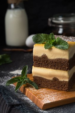 koyu bir arka plan üzerinde vanilya dolgulu çikolatalı cheesecake