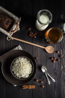 koyu ahşap arka plan üzerinde kahverengi bir kapta süzme peynir