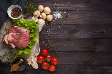 ahşap bir arka plan üzerinde malzemelerle çiğ et