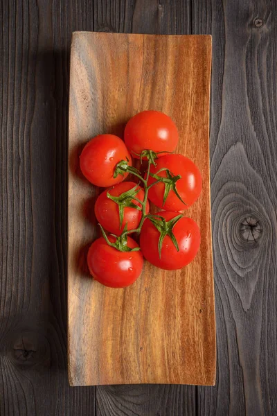 Ветвь спелых помидоров на деревянной тарелке — стоковое фото