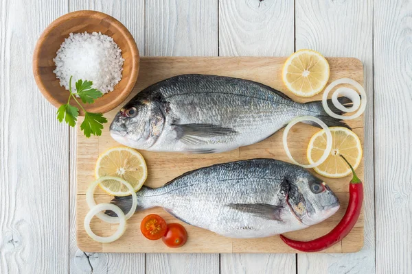 Pesce con spezie su fondo di legno — Foto Stock