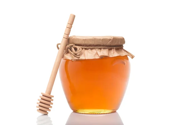 Frasco de vidro cheio de mel e pau de madeira nele — Fotografia de Stock