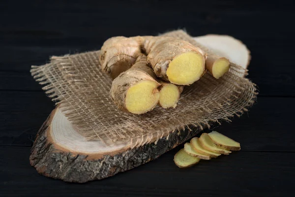 root of fresh ginger on a wooden background