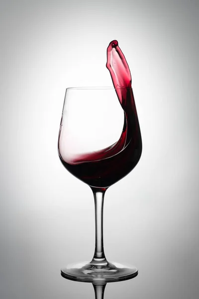 Rotwein spritzt aus einem Glas — Stockfoto