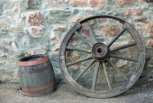 石墙上的旧木车轮和桶 — 图库照片