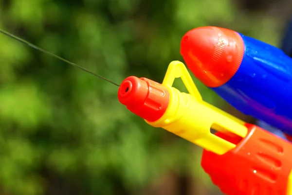 Primer Plano Una Pistola Agua Delante Arbustos Verdes — Foto de Stock