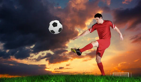 Jogador Futebol Vermelho Chutando Contra Grama Verde Sob Céu Azul — Fotografia de Stock