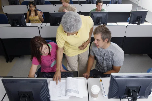 Teacher Helping Two Students Working Computer Classroom — Stock Photo, Image