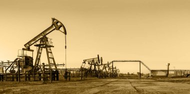 Pump jack group and wellheads. Extraction of oil. Toned. clipart
