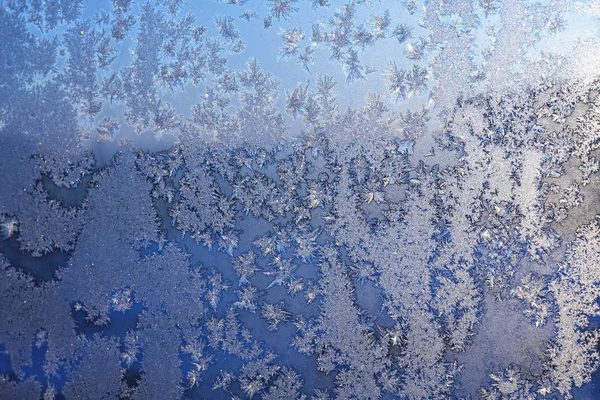 クリスマスの冬の凍った窓に氷の雪と霜のパターン グレーまたはシルバーとブルーのトーンで着色 画像のぼかしエッジを持つ選択的なフォーカス — ストック写真