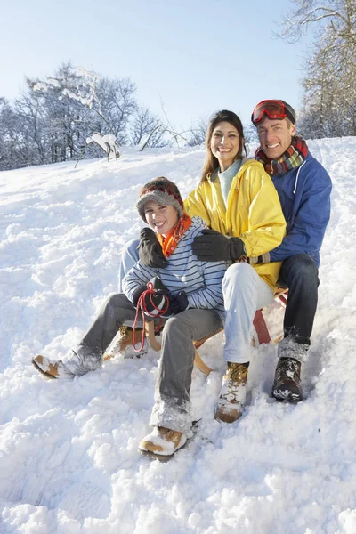 Família Desfrutando Sledging Snowy Hill — Fotografia de Stock