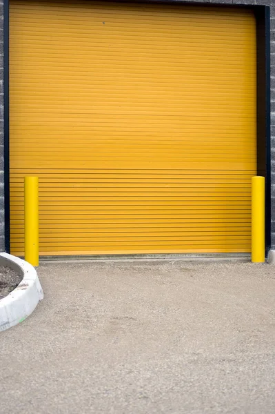 Een Kleurrijke Industriële Garagedeur Met Gele Barrières Aan Weerszijden Deze — Stockfoto