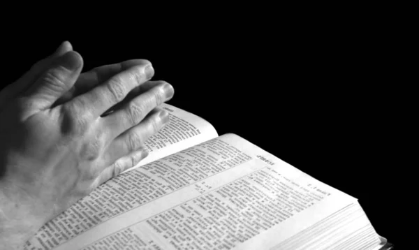 Χέρια Ενός Άντρα Ενωμένα Στην Προσευχή Πάνω Από Μια Βίβλο — Φωτογραφία Αρχείου