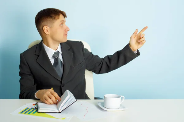 テーブルに座って若いビジネスマンは 指を指しています オフィスの様子 — ストック写真