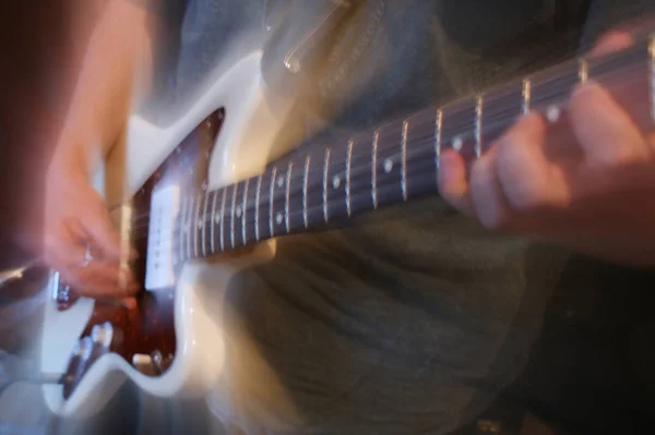 特写显示一位男吉他手演奏的白色电吉他的机身和颈部 — 图库照片