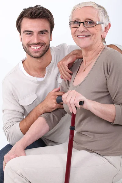 Giovane Uomo Accovacciato Donna Anziana — Foto Stock