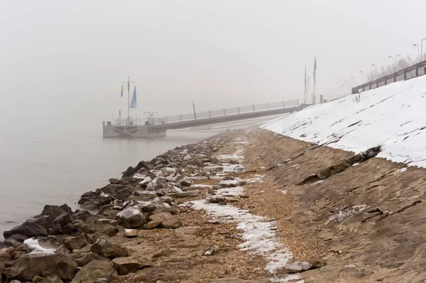 バック グラウンドで桟橋と霧の中で汚れた海岸 — ストック写真