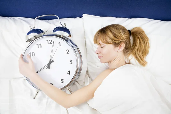 Young Woman Lying Bed Eyes Closed Holding Huge Alarm Clock — 스톡 사진