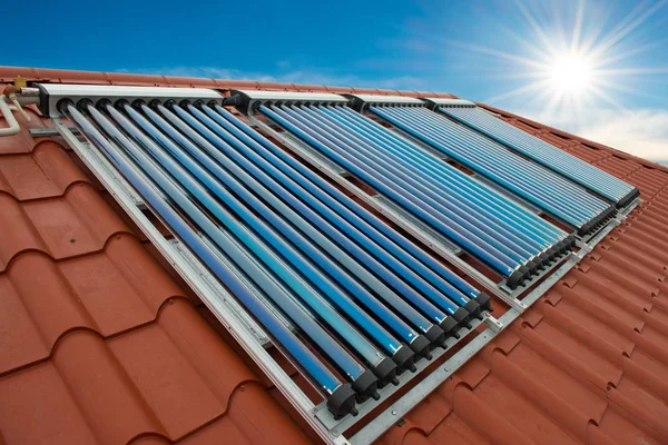 真空集热器 太阳能水加热系统在红色屋顶的房子 — 图库照片