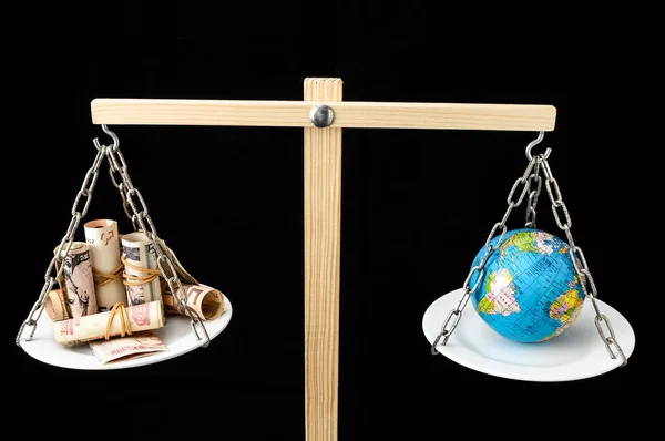 二つのパンのバランスで地球とお金を球 — ストック写真