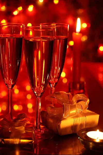 Champagne Glasses Gift Boxes Red Background Blured Lights — Stock Photo, Image