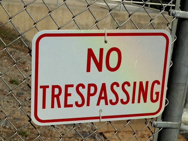 A no trespassing sign on a metal fence